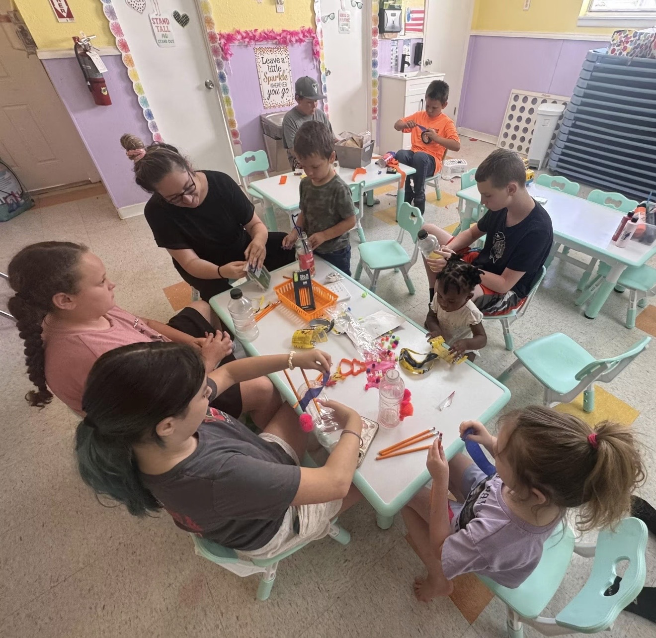 School-age children doing a craft project with teachers